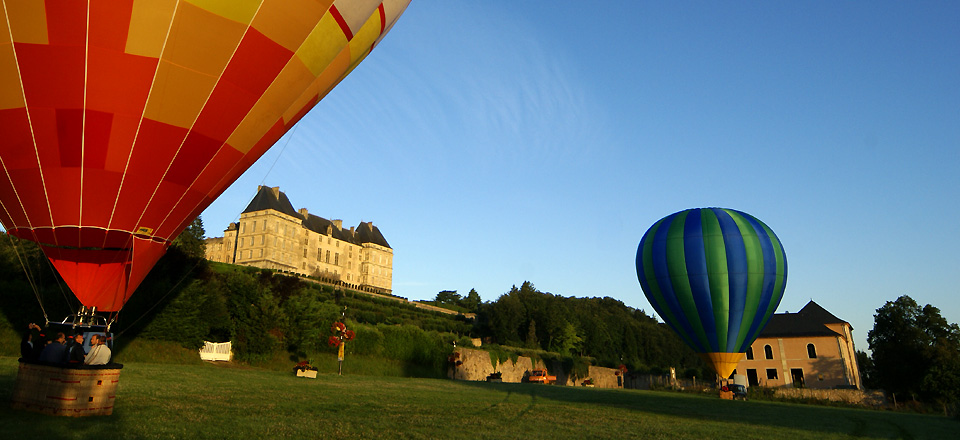Décollage de deux montgolfières au pieds du château de Hautefort en Dordogne