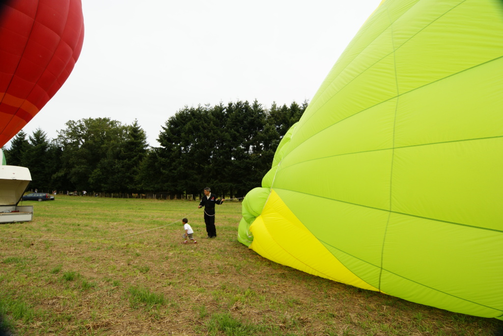 montgolfiere qui gonfle avec enfant qui tient la corde de couronne