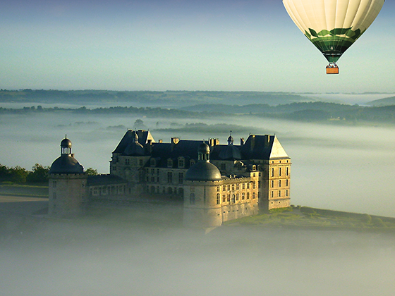 Montgolfière en vol sur le château de Hautefort en Dordogne